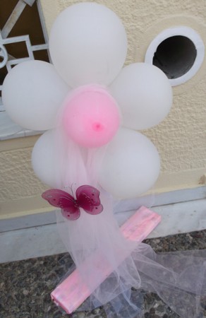 Λουλουδάκι από μπαλόνια σε στολισμένη βάση στην είσοδο της εκκλησίας